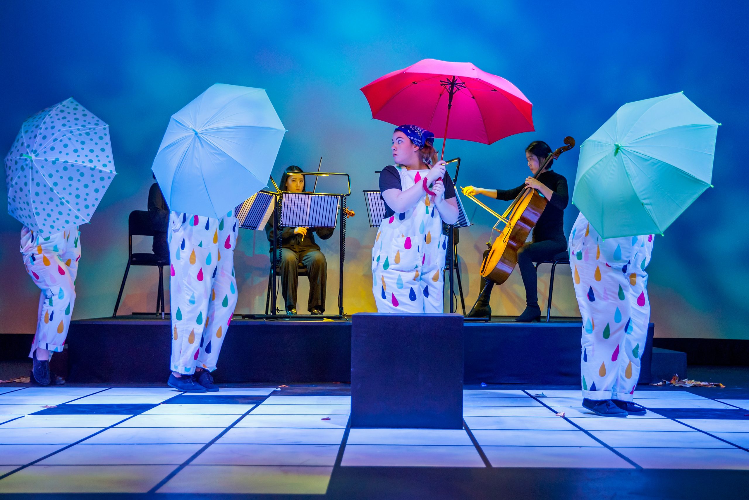 Picture of Four seasons on stage with umbrellas