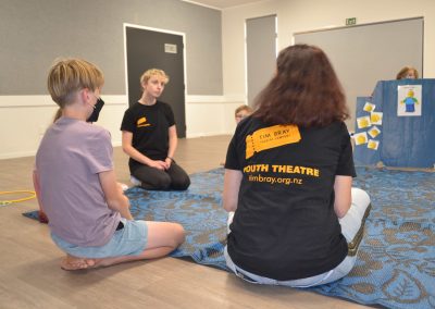 EC tutors sitting on a mat with students with a mood board