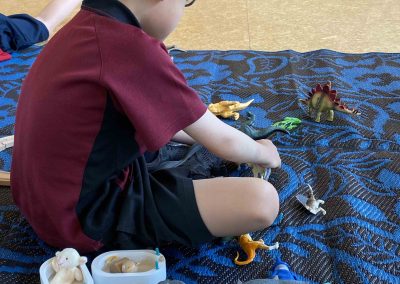 EC student sitting on a mat playing with toys