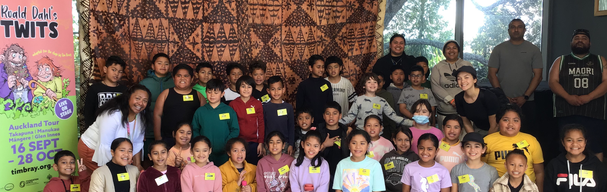 Mangere Central School students photographed in front of a show banner.